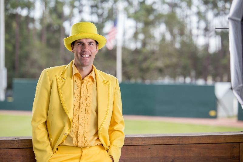 Jesse Cole, owner of the Savannah Bananas baseball team, standing on the field wearing a yellow top hat, yellow tuxedo, yellow bow tie, and yellow ruffled shirt!